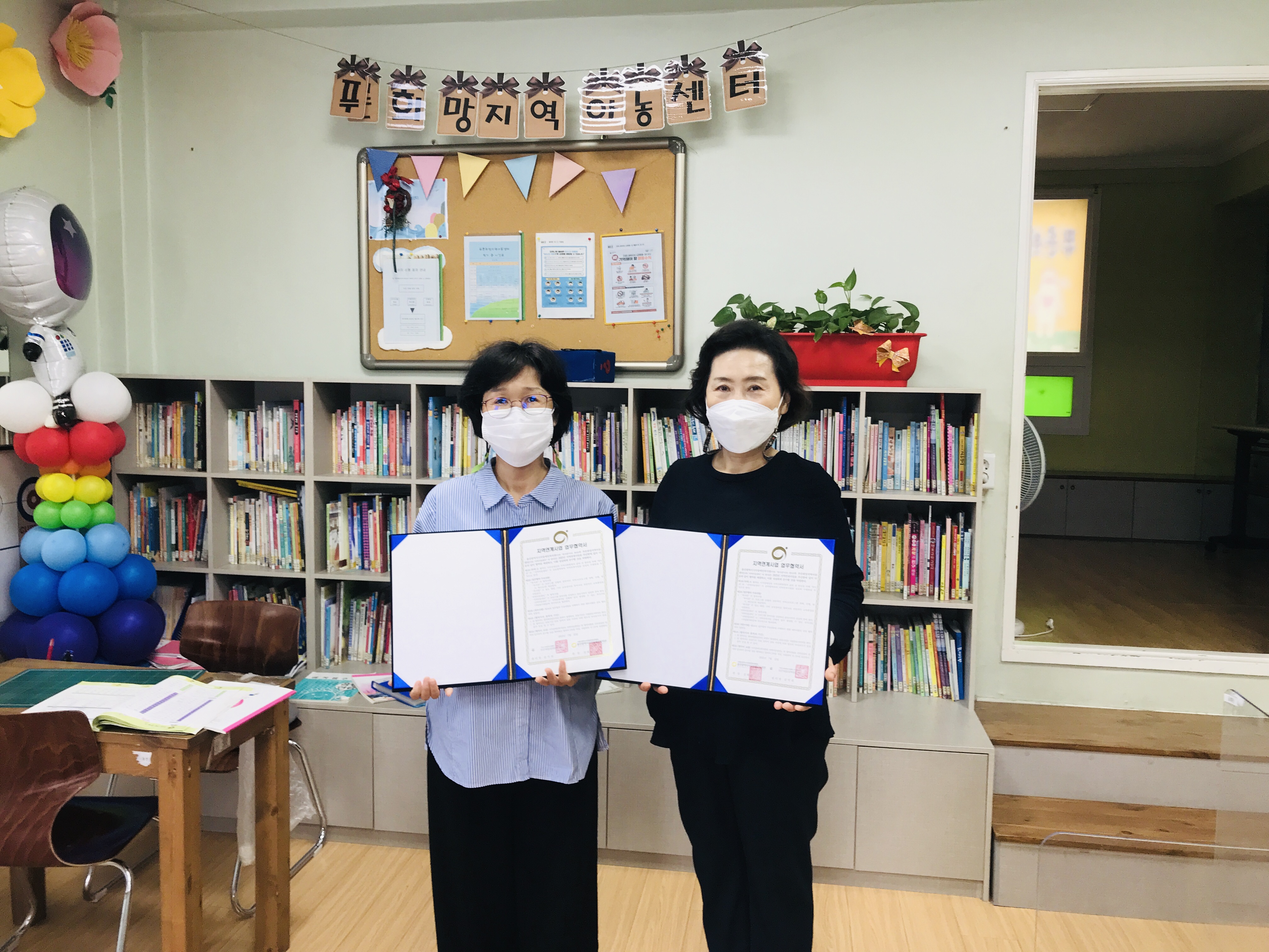 협약서를 나란히 들고 있는 사진(관장,센터장)