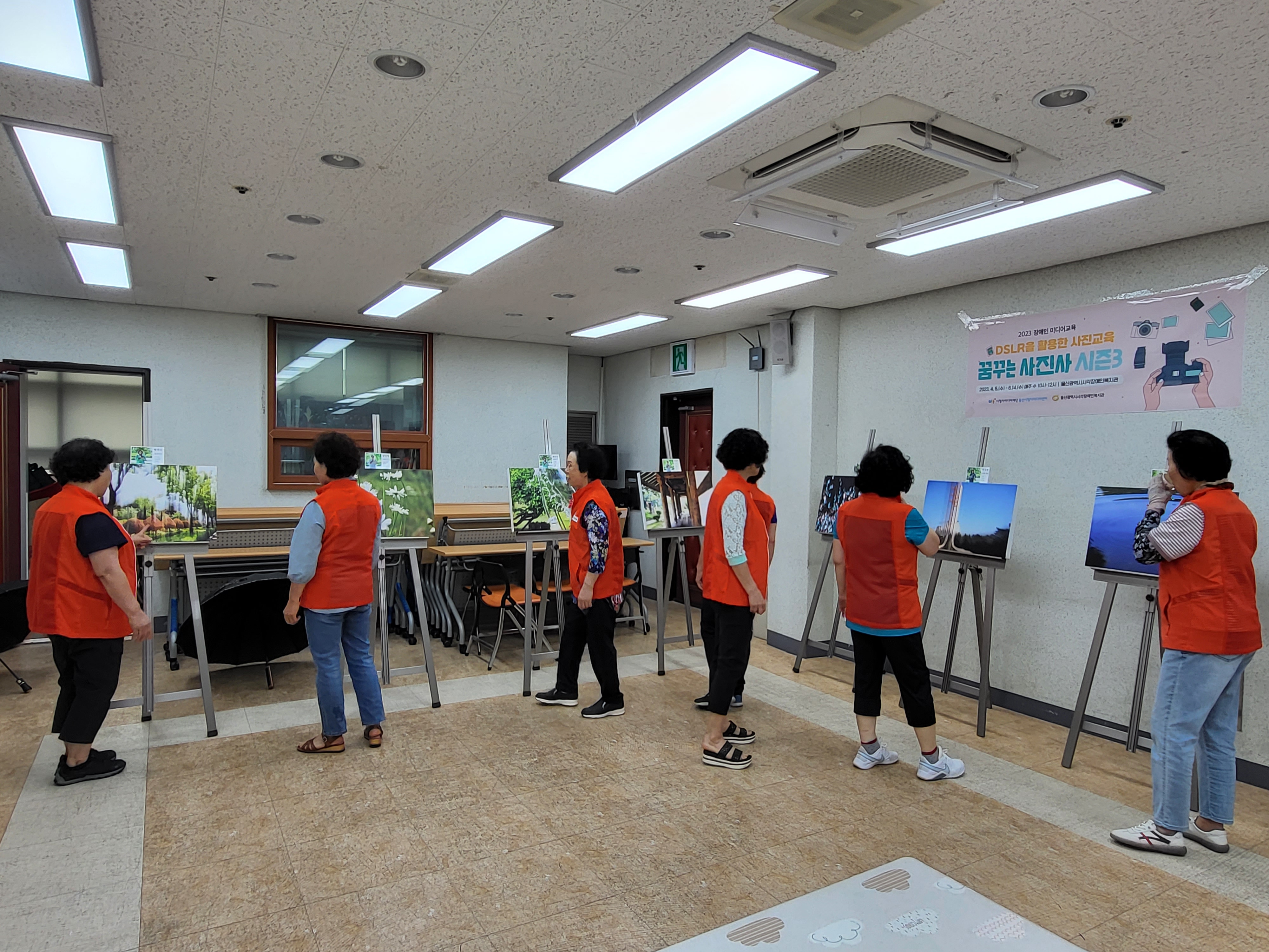 전시된 작품사진 관람하는 장면 사진